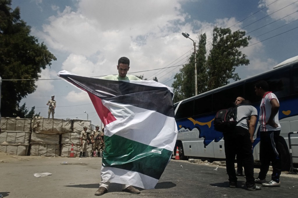 A volunteer holds the Palestinian flag at al-Balouza checkpoint.