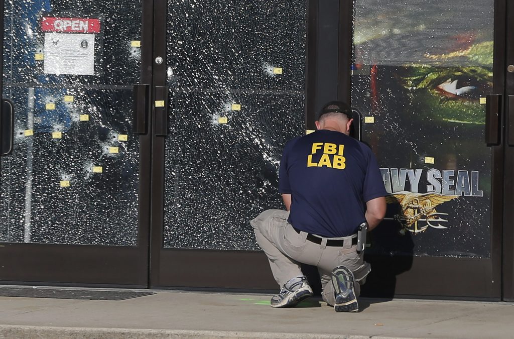An FBI investigator works to gather evidence outside a military recruiting center on Friday, July 17, 2015, in Chattanooga, Tenn. Muhammad Youssef Abdulazeez of Hixson, Tenn., attacked two military facilities on Thursday, in a shooting rampage that killed four Marines. (AP Photo/John Bazemore)