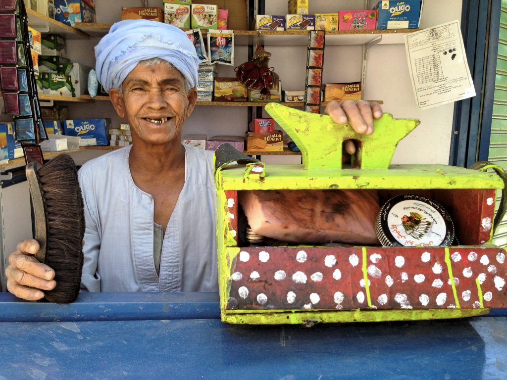Although Daooh is proud of her kiosk, she keeps her shoe-shine box nearby, just in case. 
