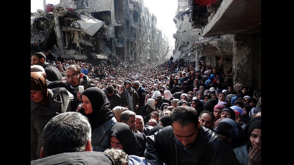 People line up for food at Yarmouk refugee camp. >Flickr/Jordi Bernabeu Farrús